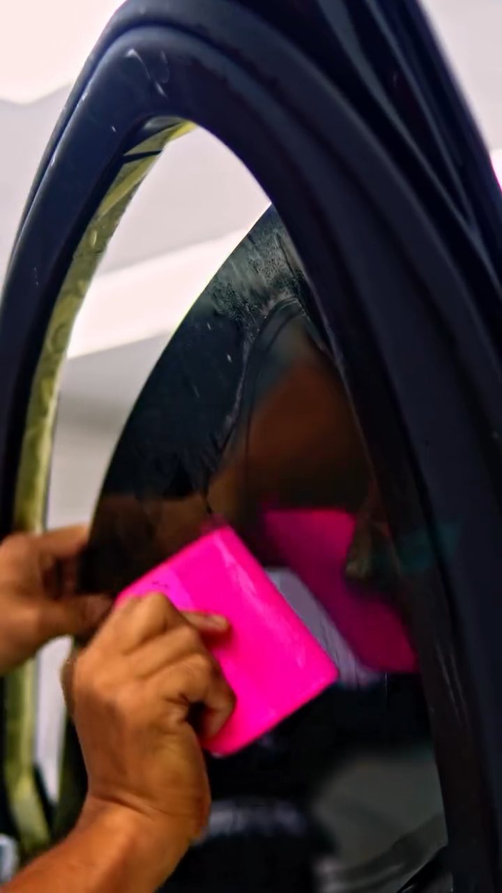 Pink squeegee finishing the Maybach S580 tint edge in Dubai