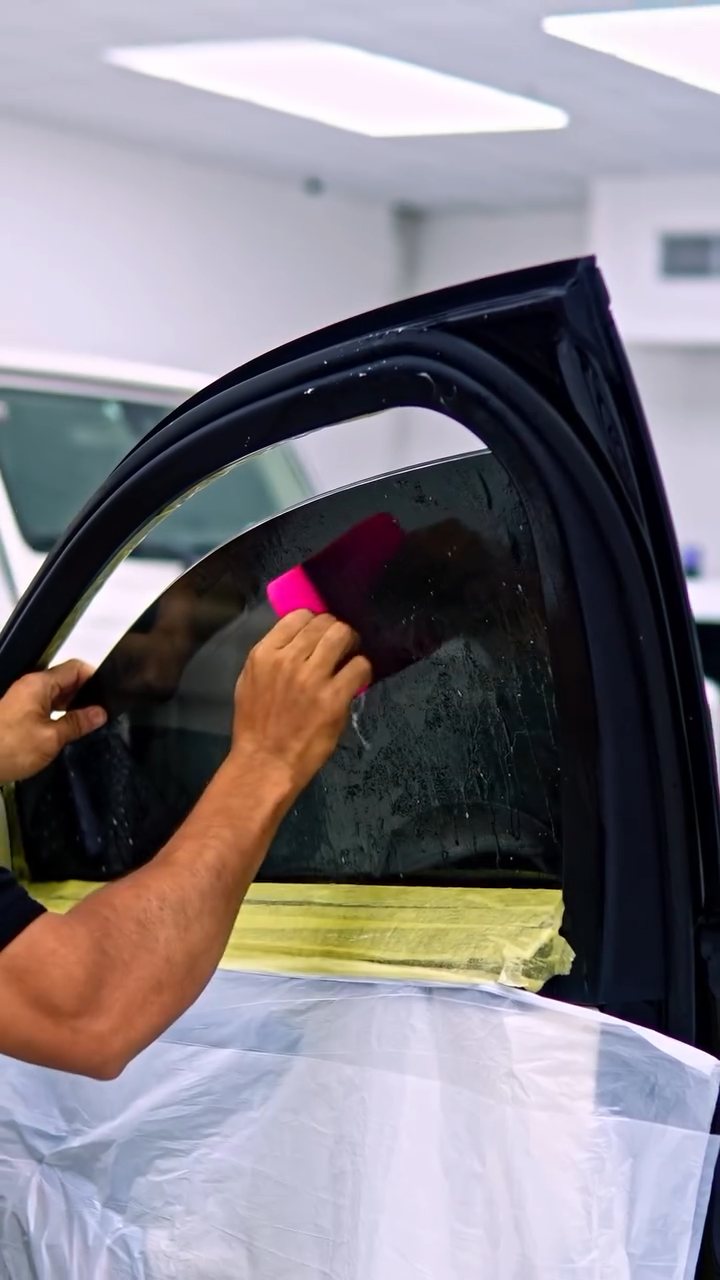 Installer squeegeeing the Maybach S580 rear door tint at Apex Detail Studio