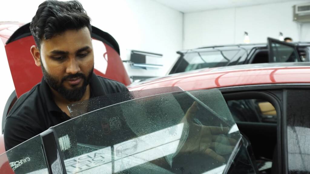 Installer fitting PPF at a Mercedes-AMG CLA frameless door