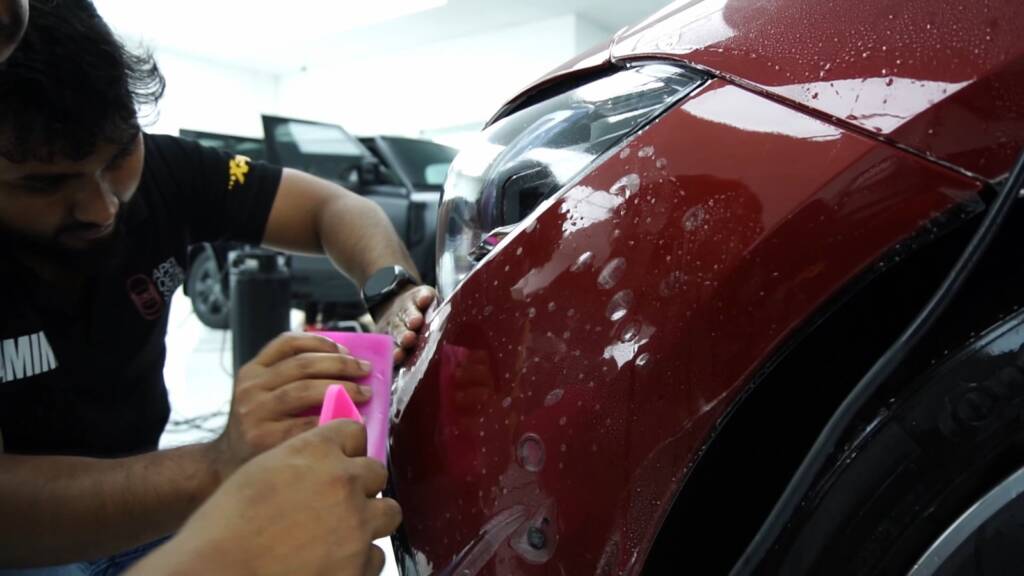 Squeegee on PPF on a Mercedes-AMG CLA rear quarter