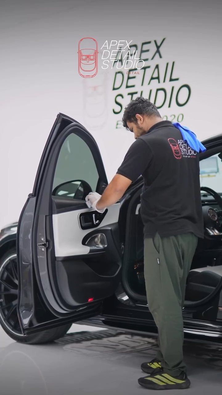 Apex detailer working in the Mercedes-AMG E53 cabin with the door open
