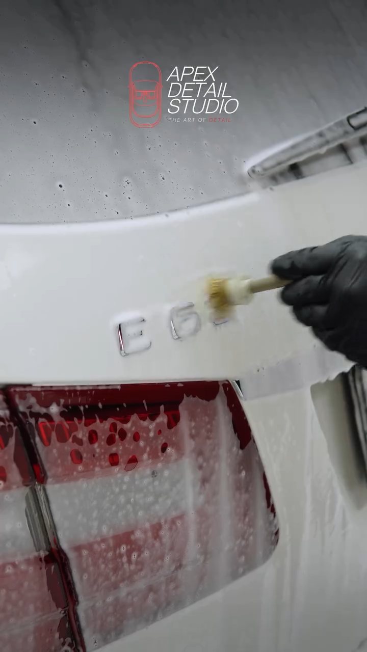 Brush cleaning around the Mercedes-AMG E63 boot badge at Apex Detail Studio Dubai