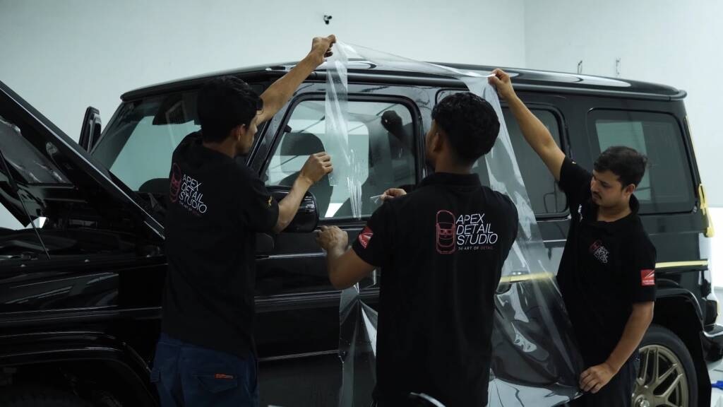 Three installers fitting PPF to a Mercedes-AMG G63 side