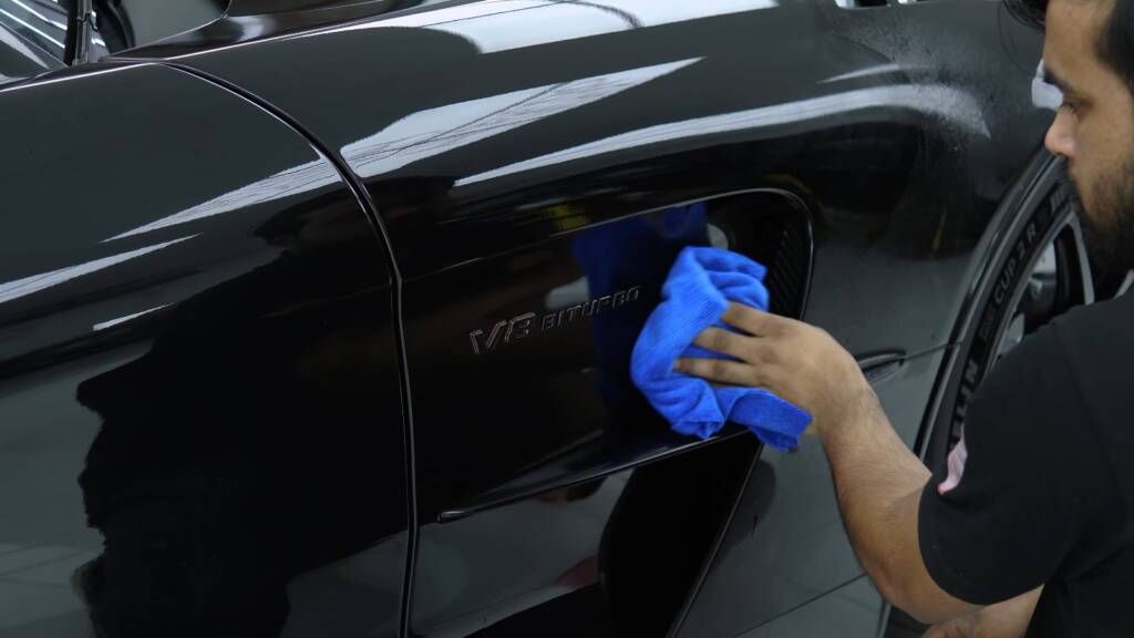 Detailer wiping the door of a black AMG GT Black Series