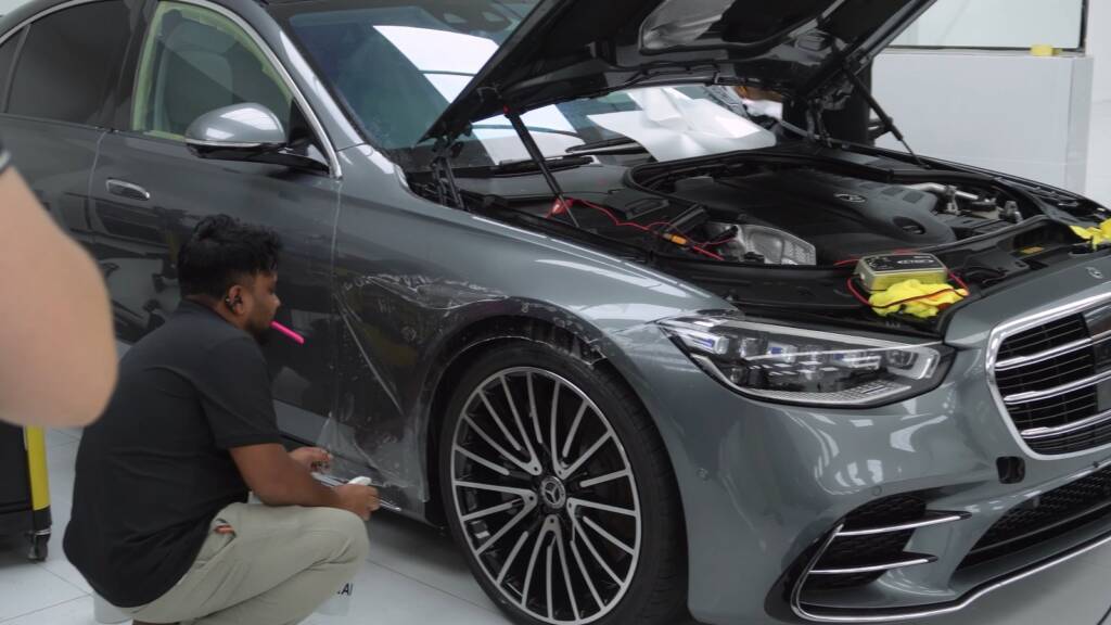 Installer preparing the front wing of a Mercedes S500 with the bonnet open before PPF