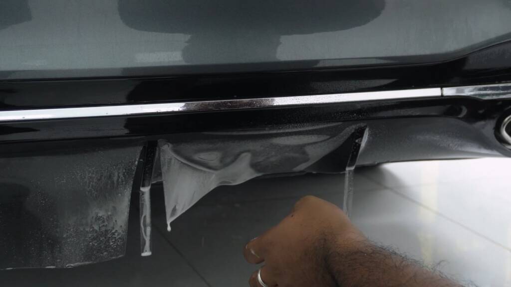 Close-up of PPF being worked along the chrome trim of a Mercedes S500