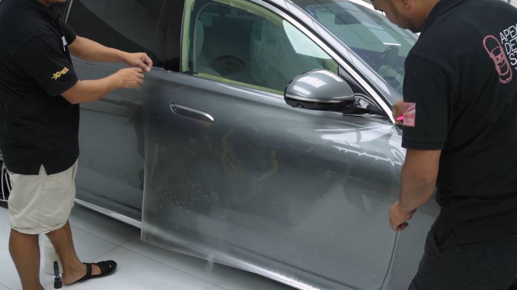 Installer applying clear PPF to the door of a Mercedes-Benz S500 in Dubai
