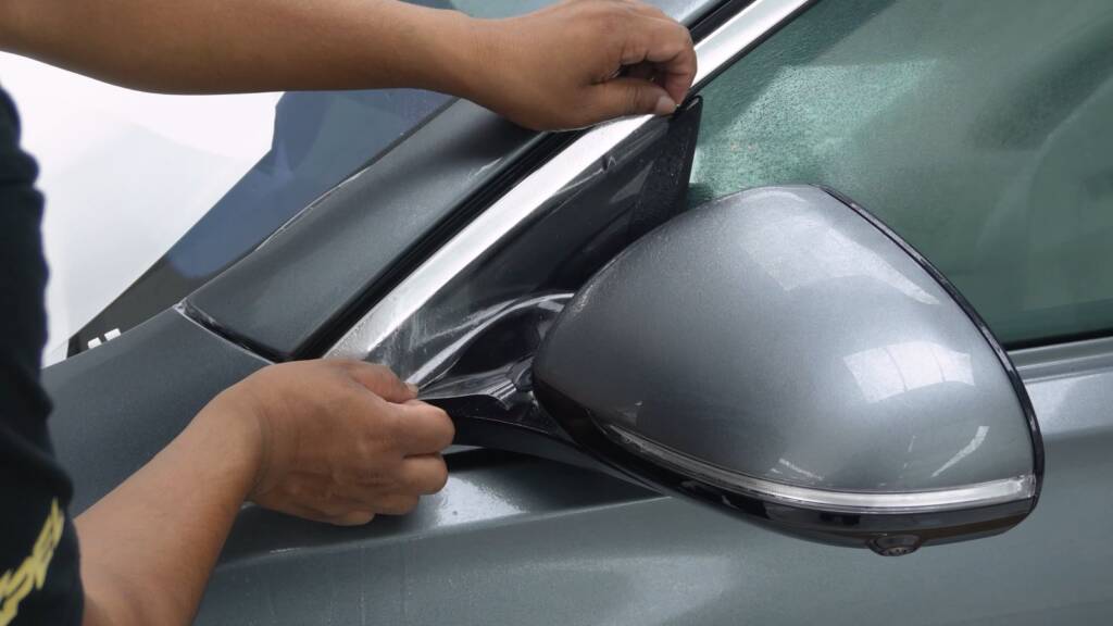 Installer fitting paint protection film to the mirror cap of a Mercedes-Benz S500