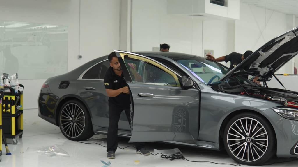 Installer checking the film along the side of a Mercedes S500 in the Apex studio