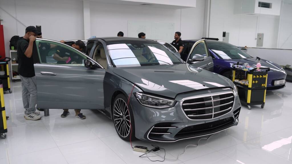 Apex team working around a grey Mercedes S500 in the studio during full PPF installation
