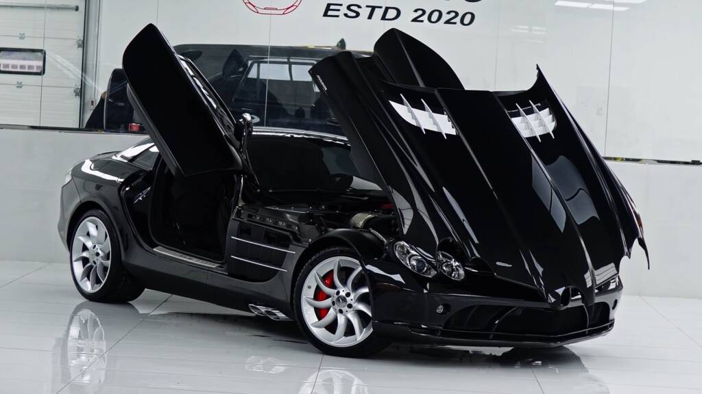 Black Mercedes-Benz SLR McLaren with butterfly doors open in the Apex Detail Studio showroom in Dubai