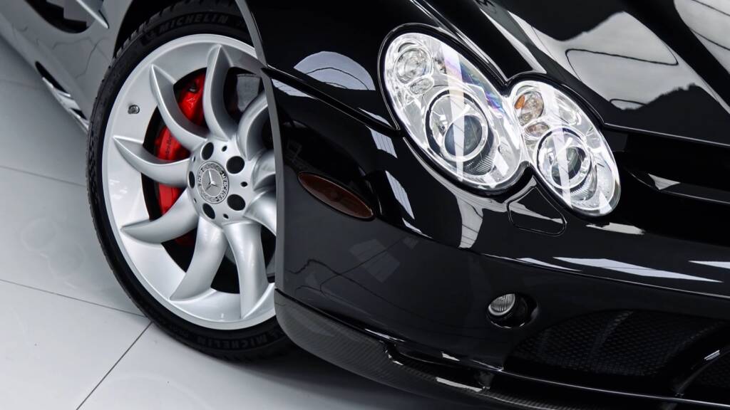 Headlights and silver wheel with red caliper on a black Mercedes SLR McLaren after detailing in Dubai