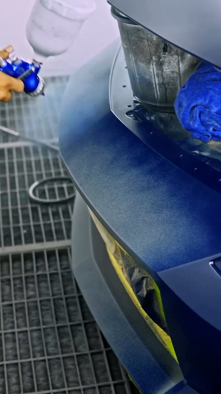 Blue peelable paint going onto the Nissan Z bumper in the spray booth