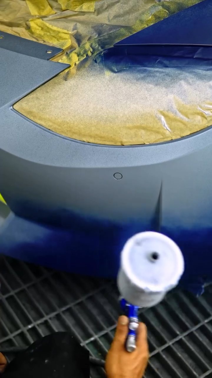 Spray gun applying blue peelable paint to the Nissan Z front at Apex Detail Studio Dubai