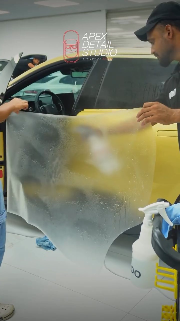 Apex installer fitting a sheet of matte PPF onto the Polestar 4 door in Dubai