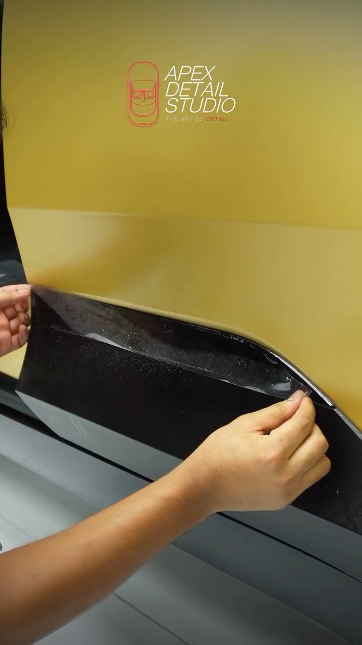 Hands wrapping the matte PPF edge on the Polestar 4 lower panel in Dubai