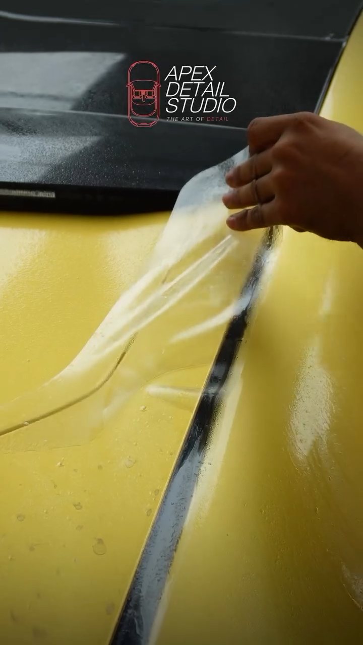 Installer positioning matte PPF across the Polestar 4 tailgate at Apex Detail Studio