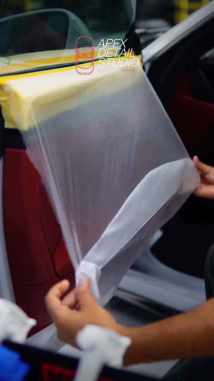 Installer handling a cut tint film for the Porsche 911 Carrera GTS