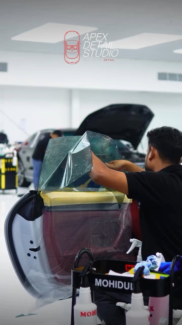 Installer working on the Porsche 911 Carrera GTS rear glass tint at Apex Detail Studio