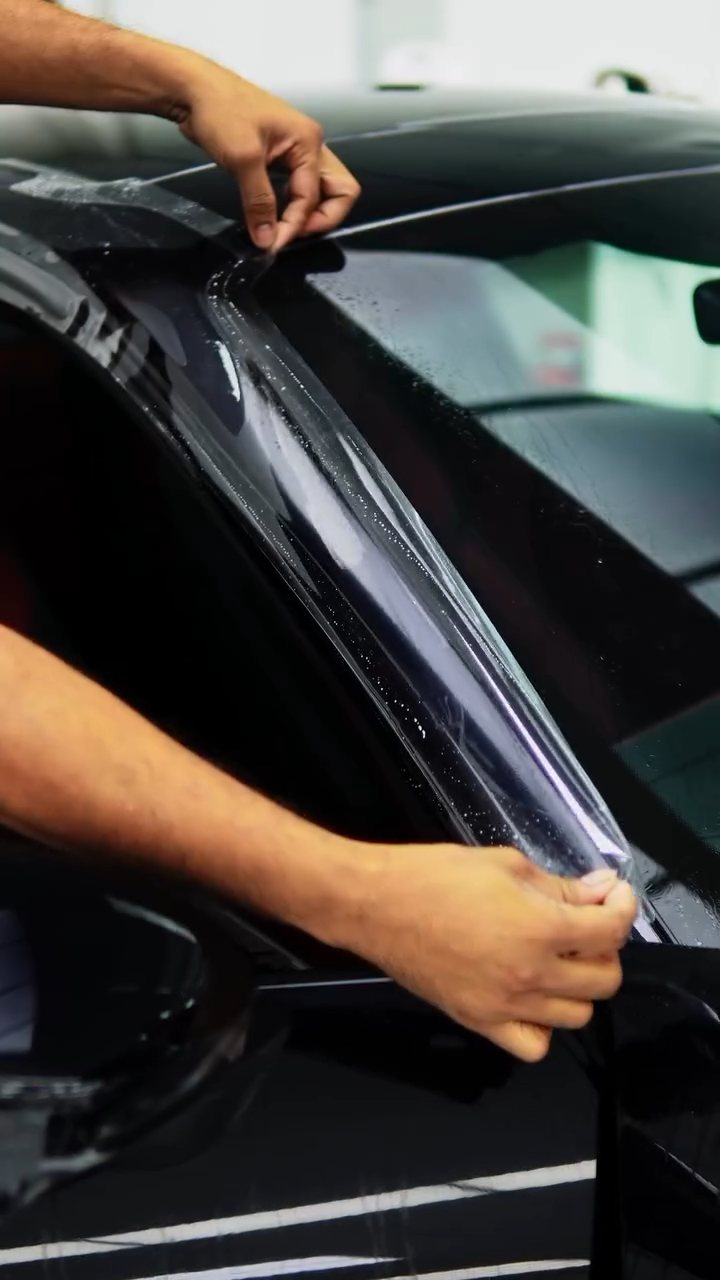 Installer wrapping PPF around the Porsche 911 Carrera window pillar