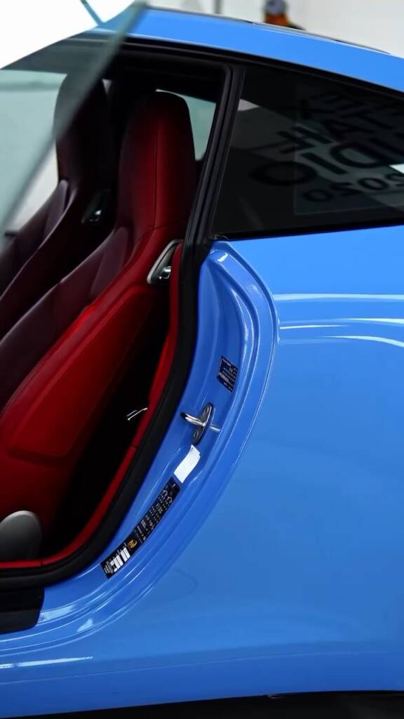 Porsche 911 Carrera door open showing blue colour PPF and red leather interior in Dubai