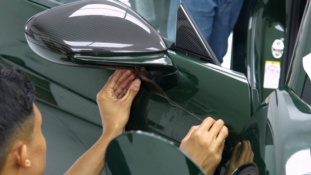 Installer fitting PPF around the mirror of a new Porsche 992.2 GT3 at Apex Detail Studio