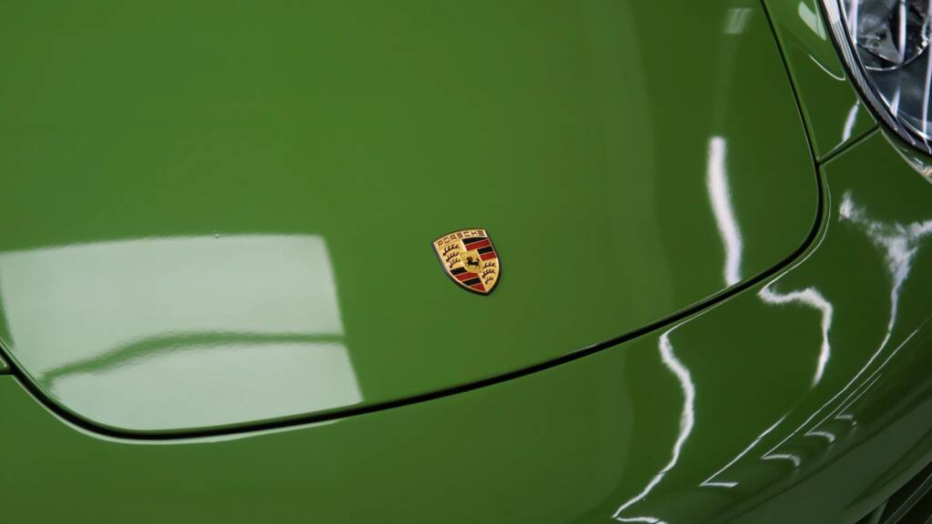 Porsche crest on the green bonnet of a 911 997 after colour change PPF in Dubai