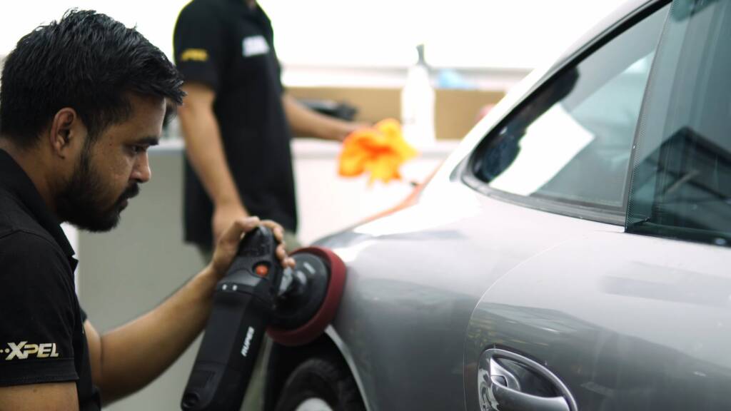 Machine polishing silver paint on a Porsche 911 997 before colour change PPF in Dubai