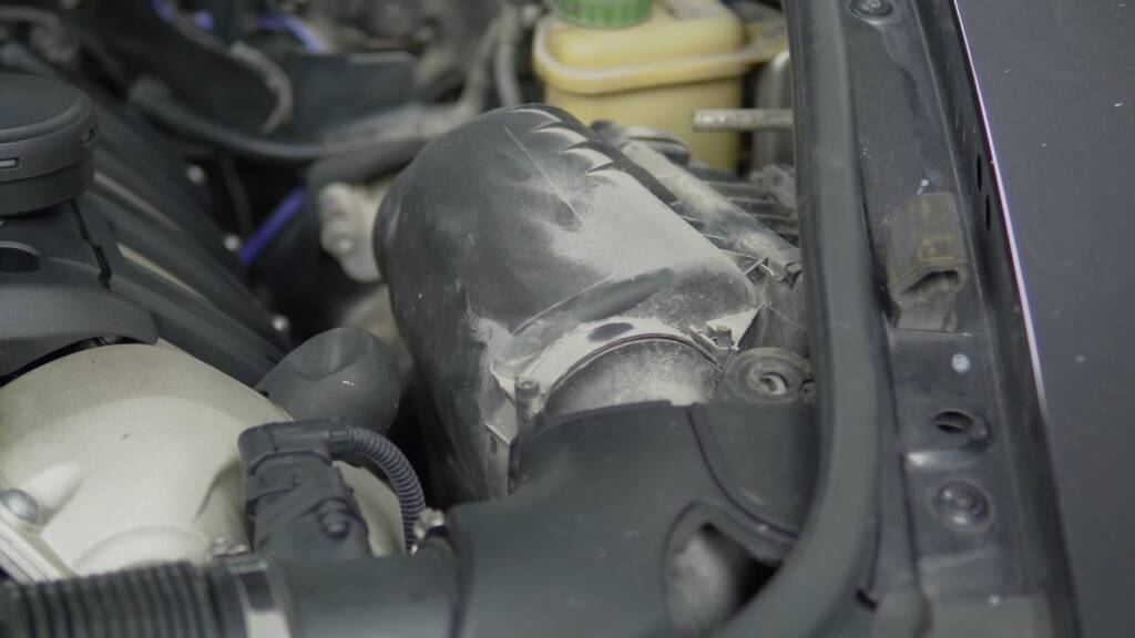 Hoses and covers in a Porsche Cayenne engine bay during cleaning