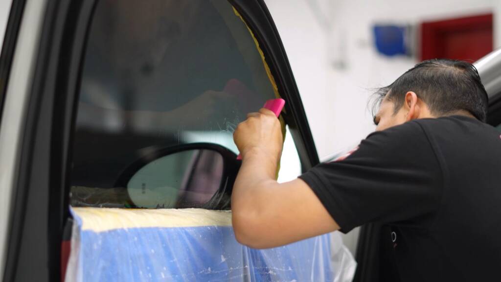 Window tint being fitted inside a Porsche Cayenne GTS door