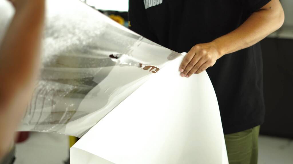 Installer handling a PPF sheet for a Porsche Cayenne GTS
