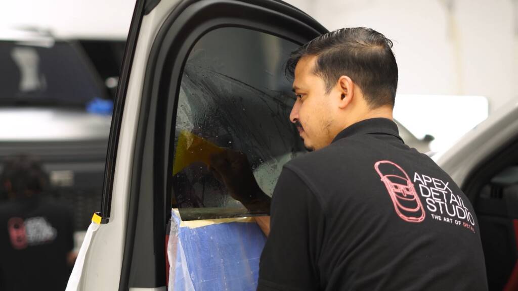 Installer fitting window tint on a Porsche Cayenne GTS