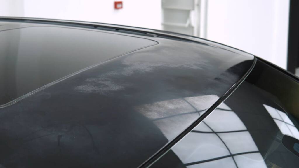 Gloss black roof of a Porsche Cayenne after paint correction and ceramic sealant