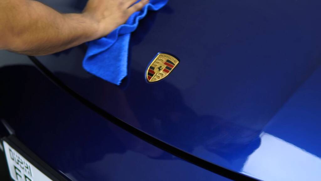 Porsche crest on the bonnet of a blue Taycan after PPF