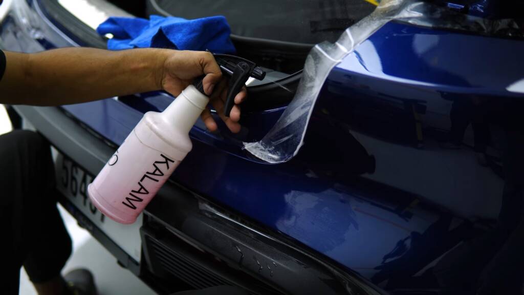 Slip solution sprayed on the front bumper of a Porsche Taycan before PPF