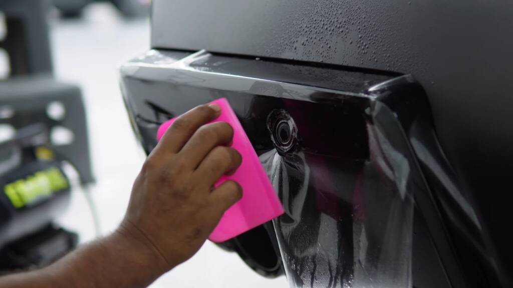 Paint protection film being applied to the rear diffuser trim of a BMW M5 Touring