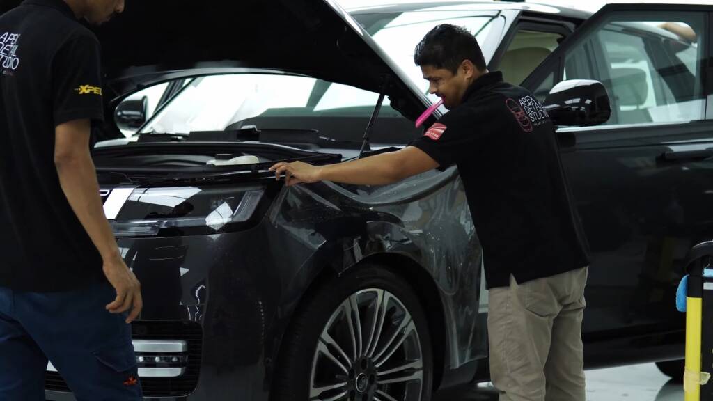 Installer fitting PPF on a Range Rover Autobiography bonnet