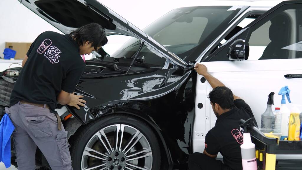 Apex team fitting gloss black colour PPF to the front of a Range Rover