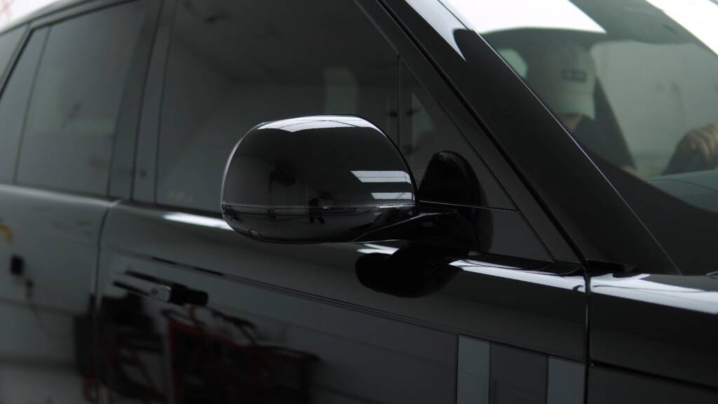 Gloss black mirror and door of a Range Rover after colour PPF