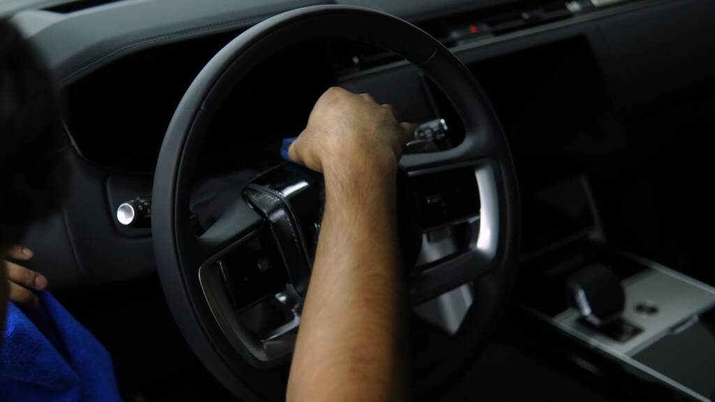 Detailer cleaning the steering wheel of a Range Rover