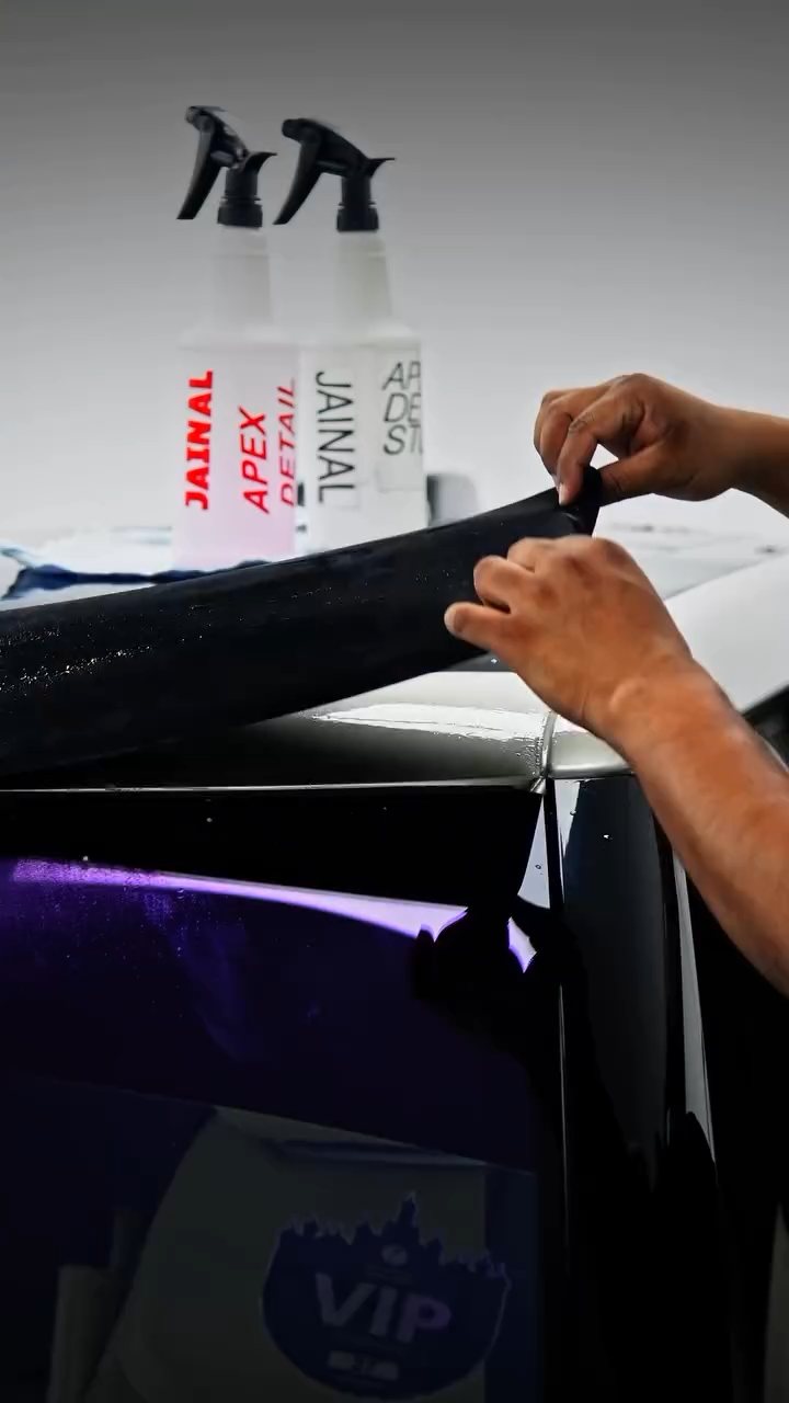 Installers working grey colour PPF along the Range Rover roof edge