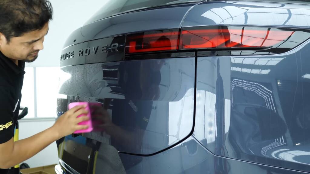 Installer fitting precut PPF on the tailgate of a 2025 Range Rover Sport