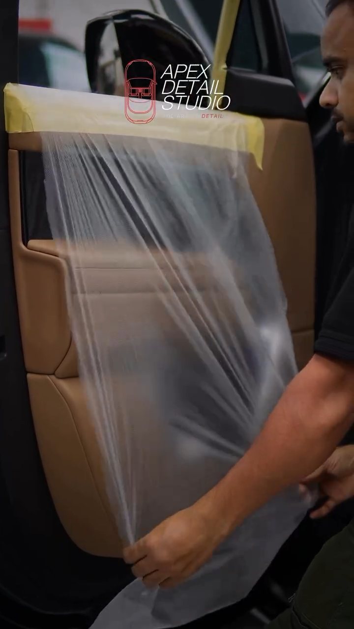 Installer taping protective plastic over the Range Rover door card in Dubai