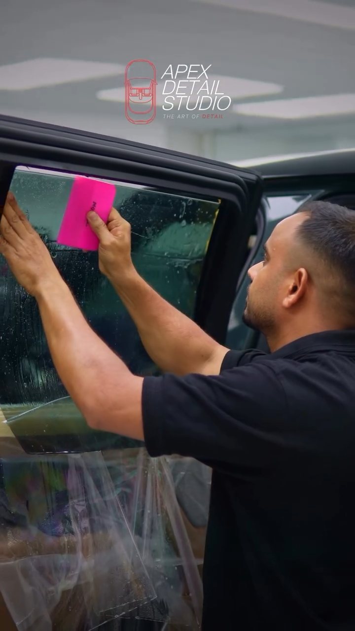 Apex installer fitting tint to the Range Rover rear door glass in Dubai