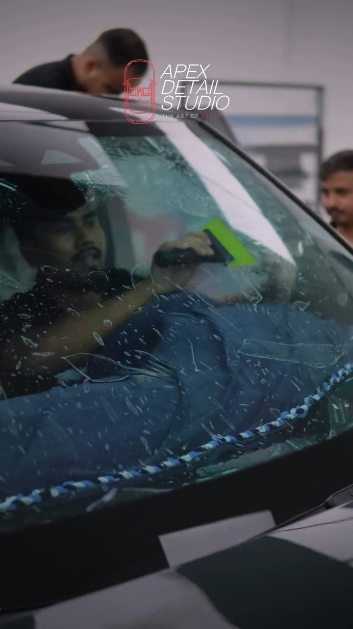 Installer working on the Range Rover front glass from inside in Dubai