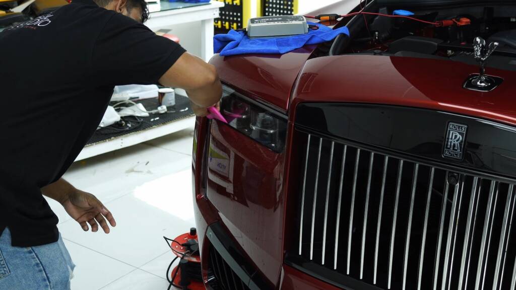 Installer at the front corner of a Rolls-Royce Cullinan