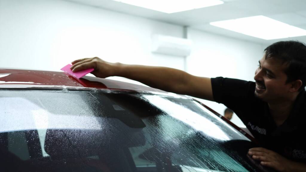 Squeegee on PPF at a Rolls-Royce Cullinan roof edge