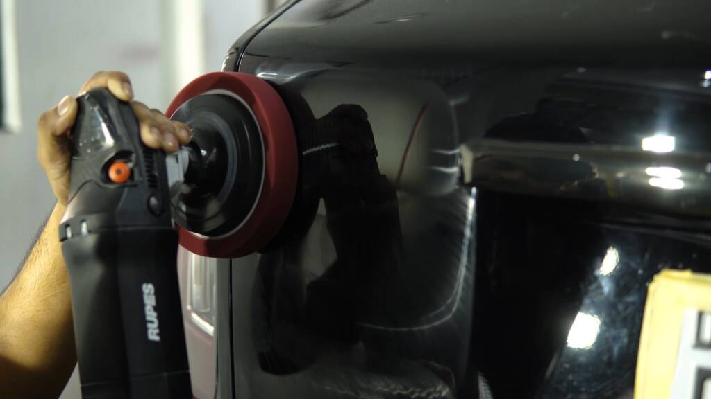 Machine polishing a black Rolls-Royce Cullinan rear panel