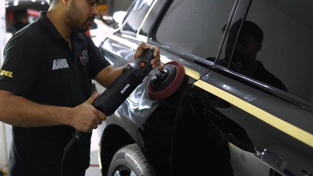 Paint correction on the side of a black Rolls-Royce Cullinan
