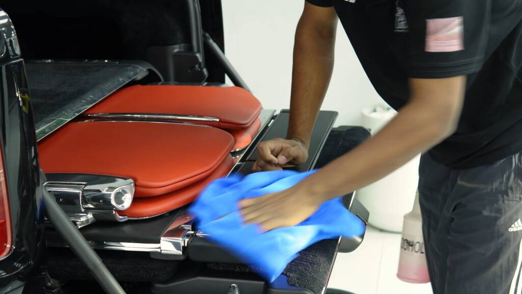 Cleaning the red Viewing Suite seats of a Rolls-Royce Cullinan